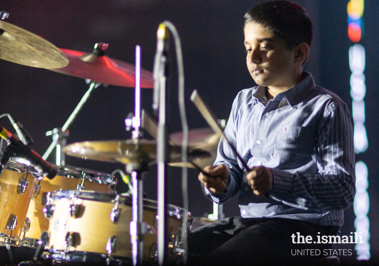 Artist in the talent category, playing the drums as part of his performance.