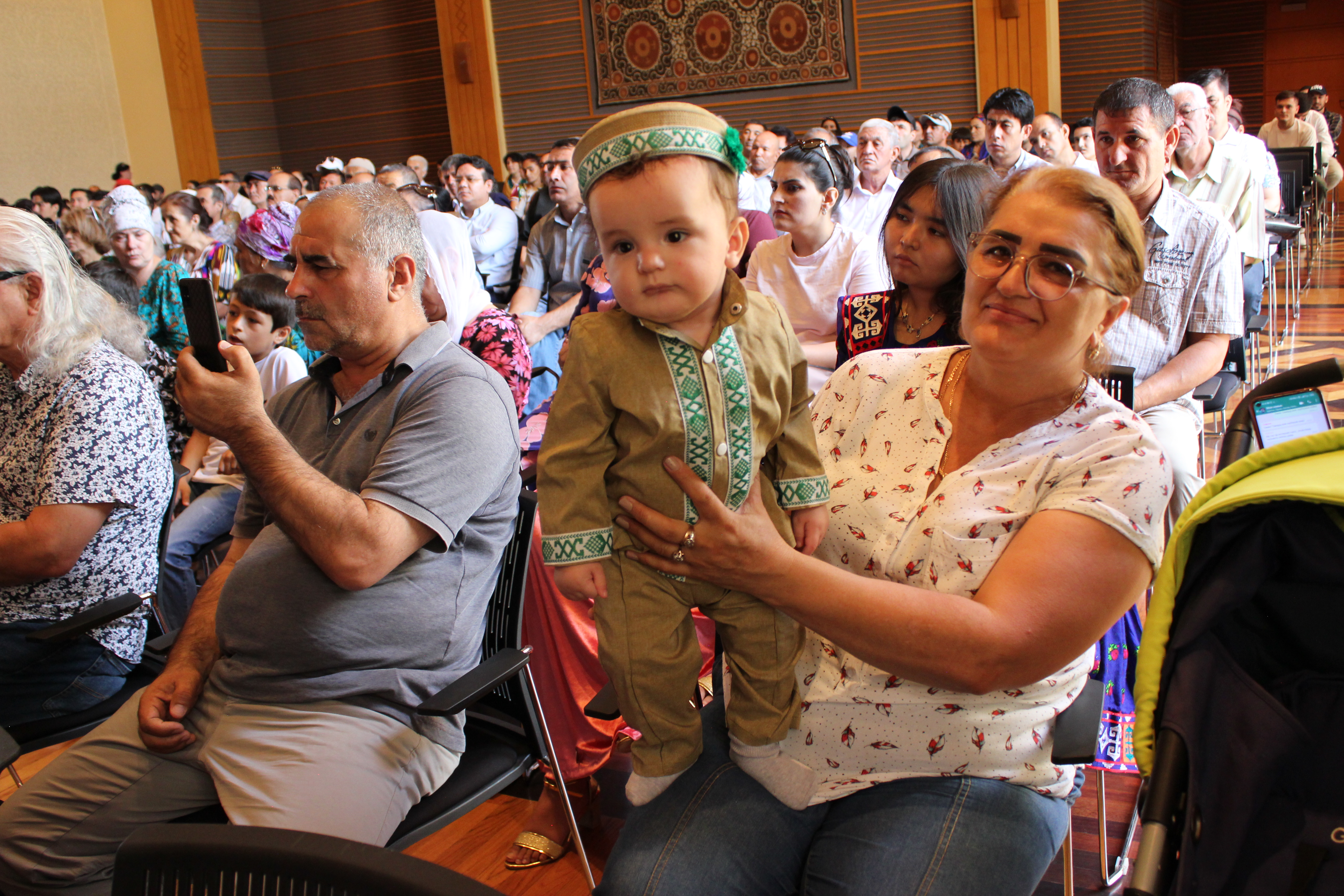 A little kid enjoying the musical performance at the Imamat Day event