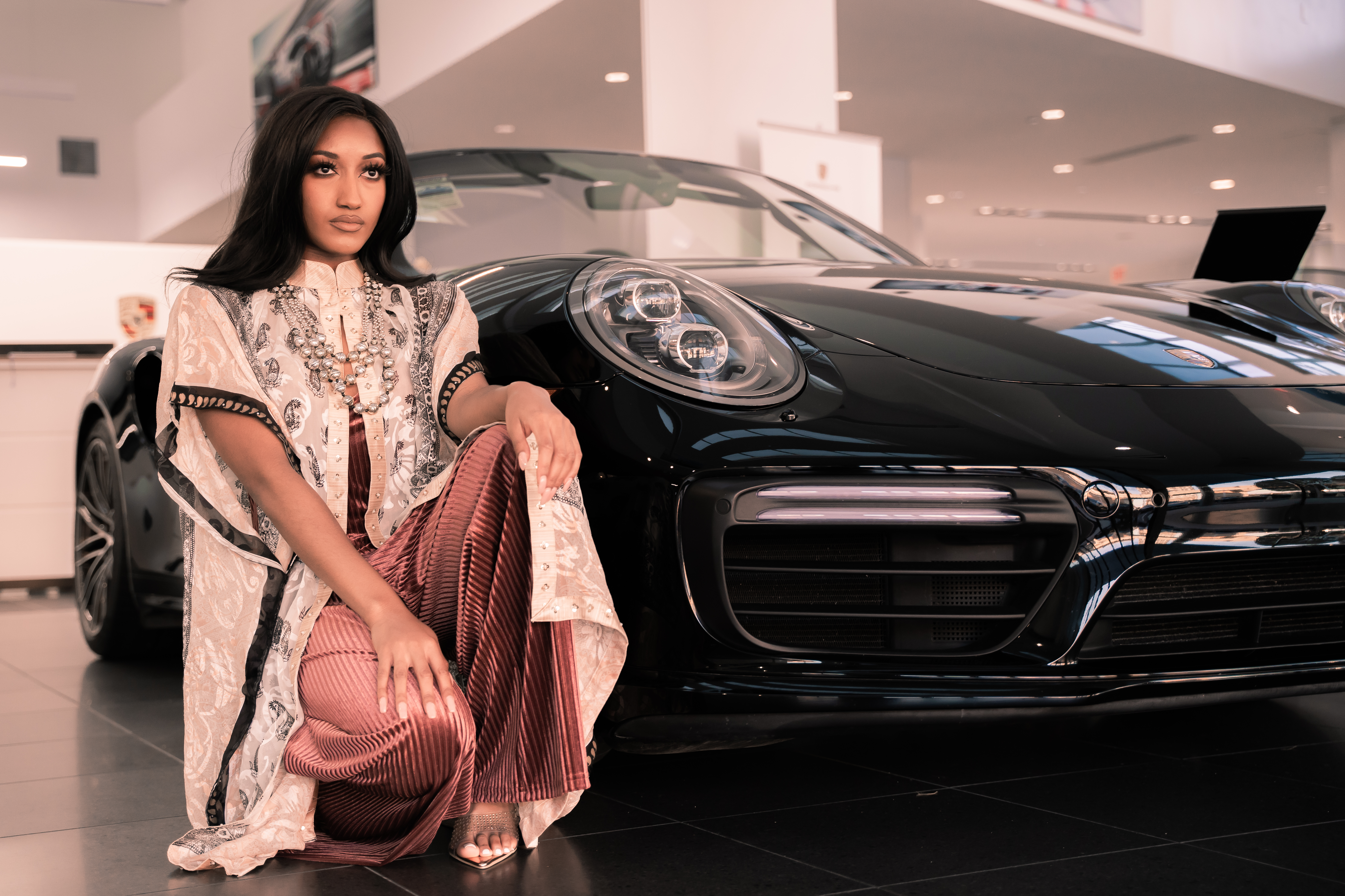 A model wearing a Heritage design next to a Porsche, reflecting the collaboration with Heritage.