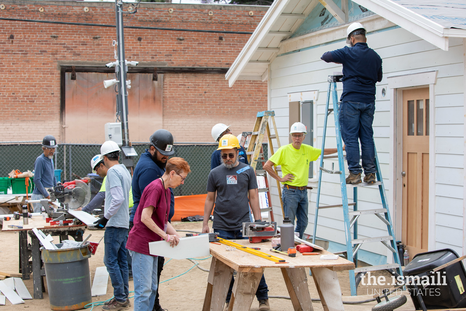 Volunteers measure a piece of siding. Photo: Seema Ali.