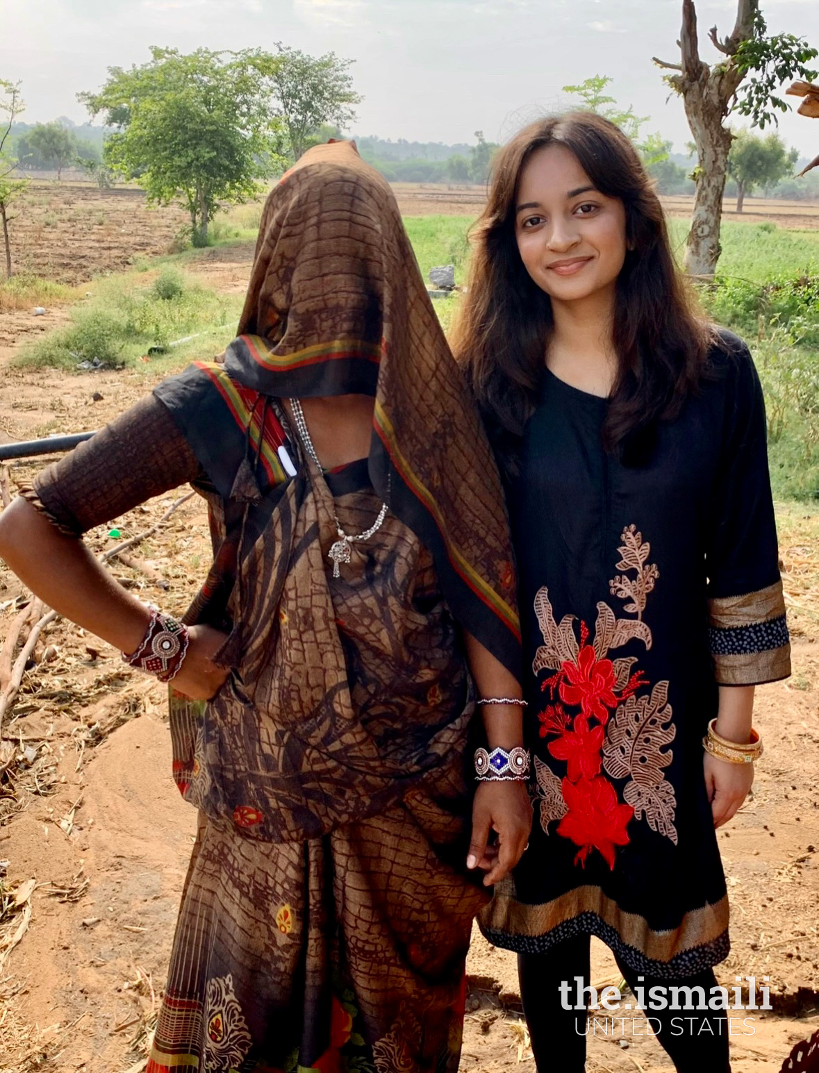 Standing beside a veiled woman – who prefers keeping her veil as a sign of respect towards guests and whose tireless work in the fields sustains and nourishes the village.