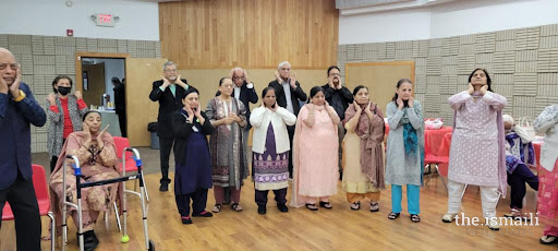 Seniors at Atlanta Northwest Jamatkhana doing face yoga.