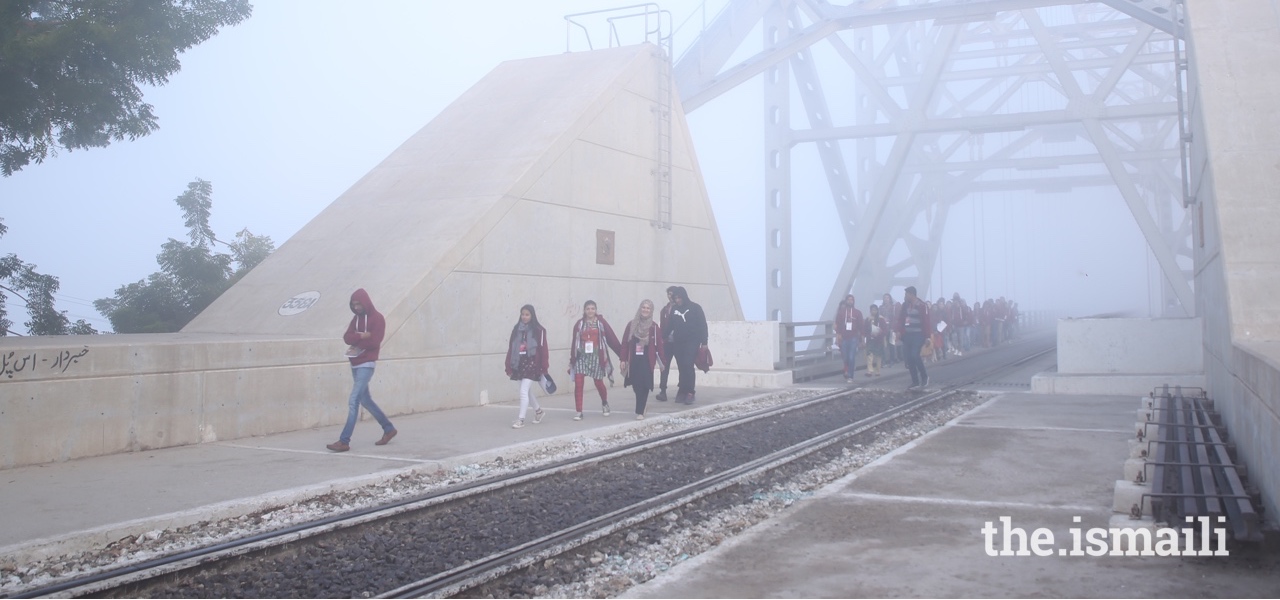 On a misty morning, HDT participants walk across the Sukkur bridge.