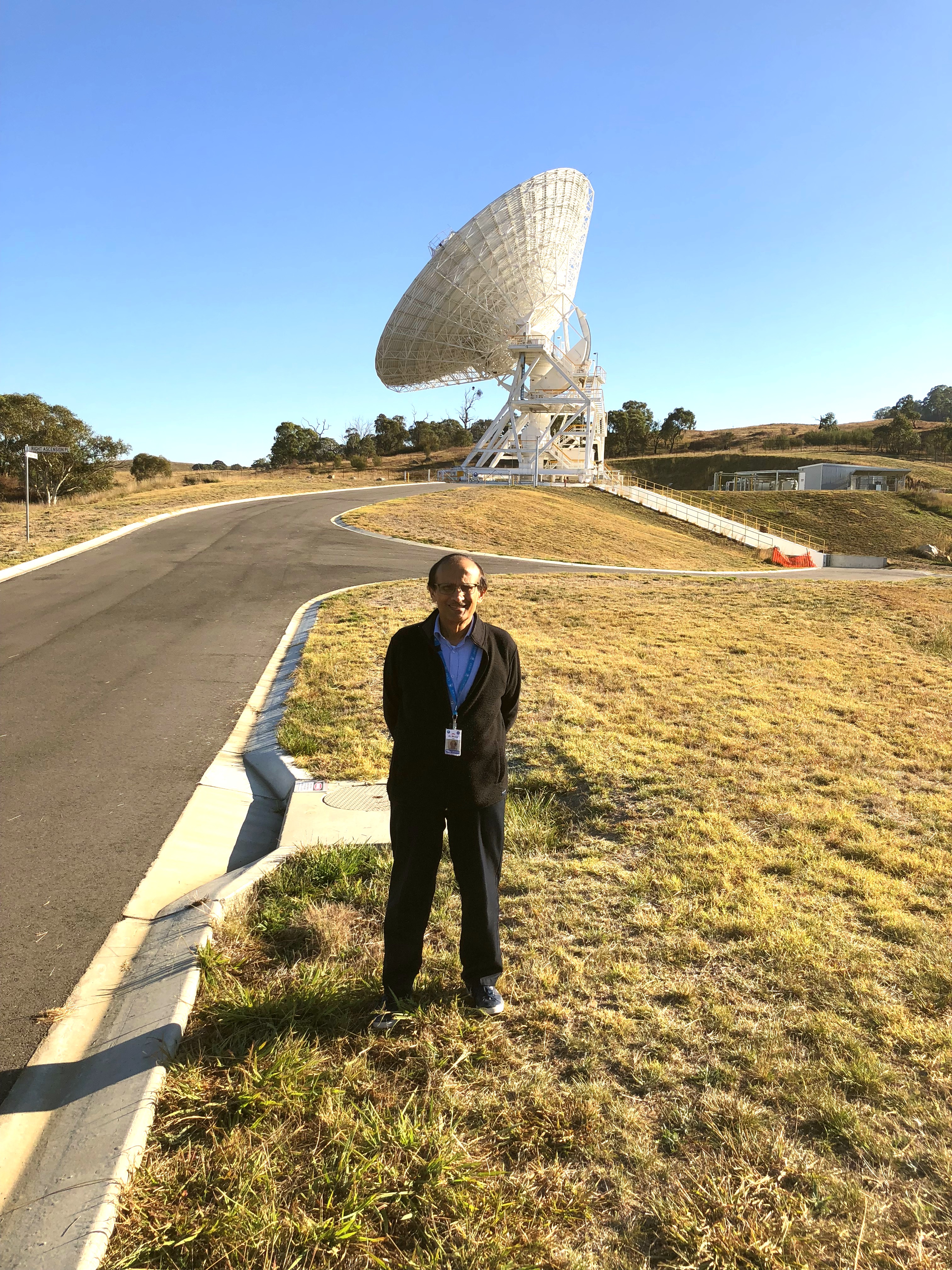 Alaudin Bhanji in front of the newest antenna built under his leadership in Australia.