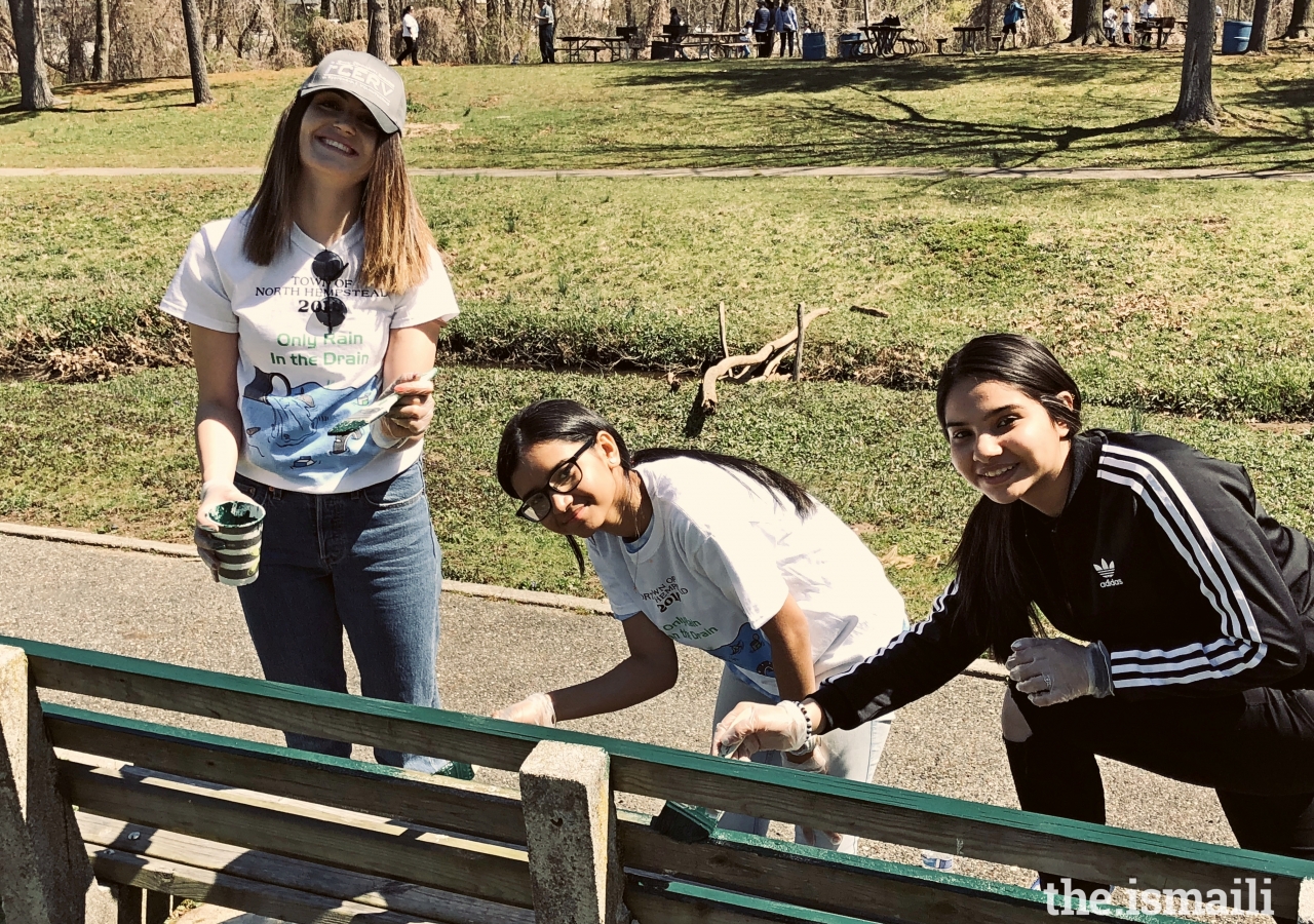 Volunteers painting a bench at Whitney Pond park, Long Island, NY.