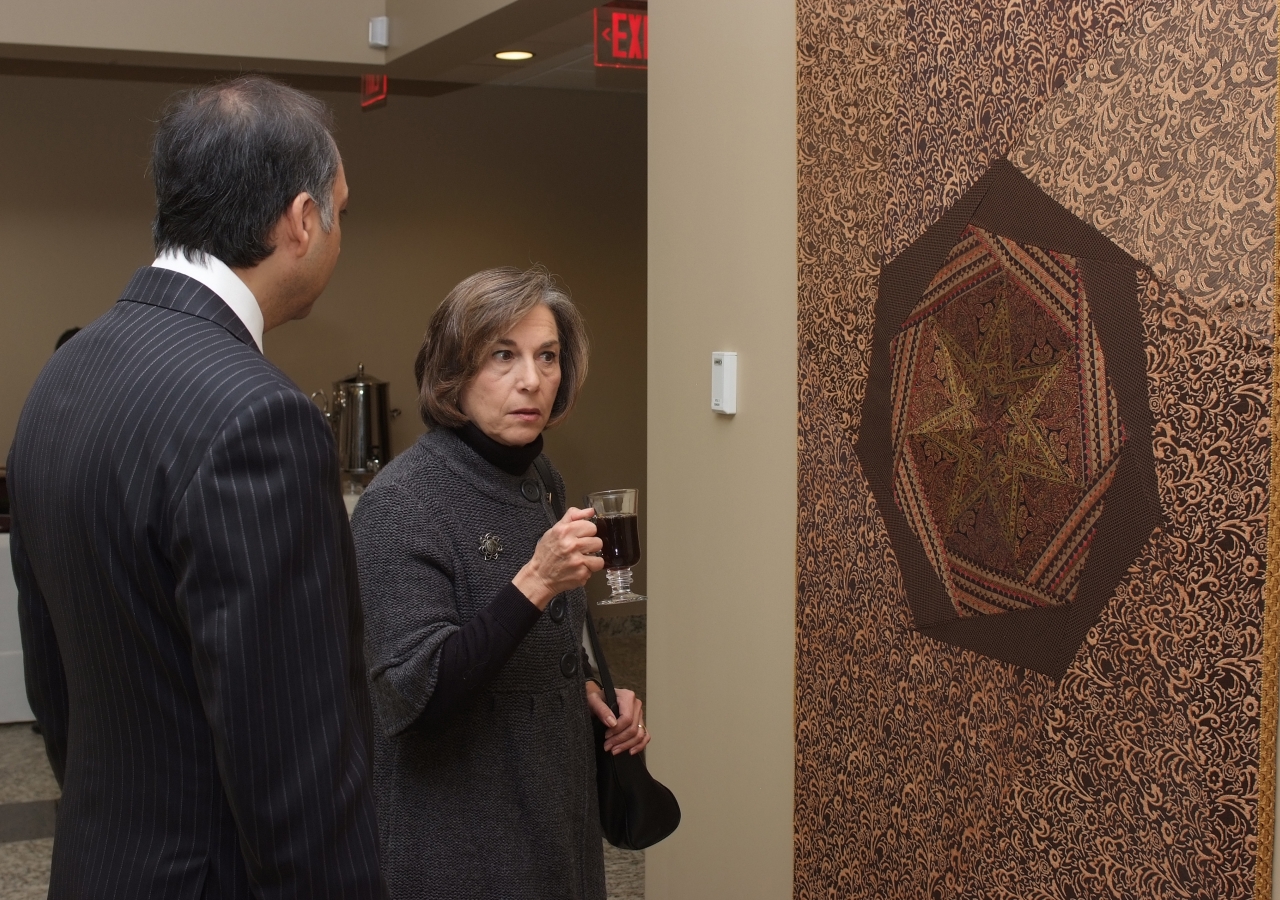 Congresswoman Jan Schakowsky and President Mahmoud Eboo admire a tapestry stitched by volunteers from the Jamat. 