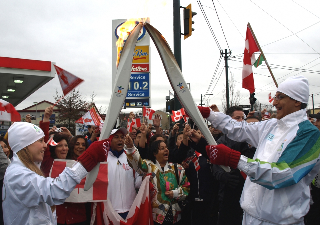 Vice-President Malik Talib passes on the flame after his run.