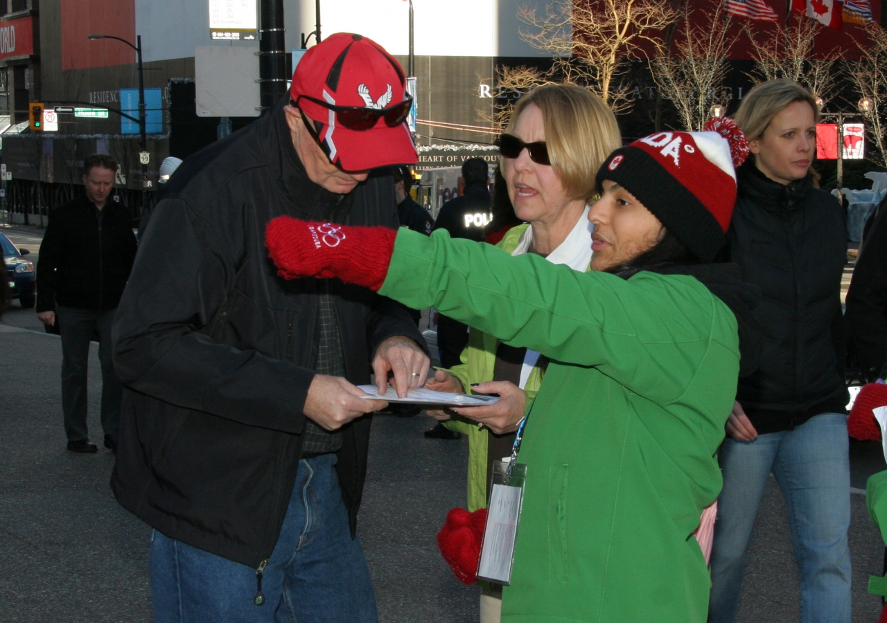 A young Ismaili volunteer offers directions to tourists in Vancouver.