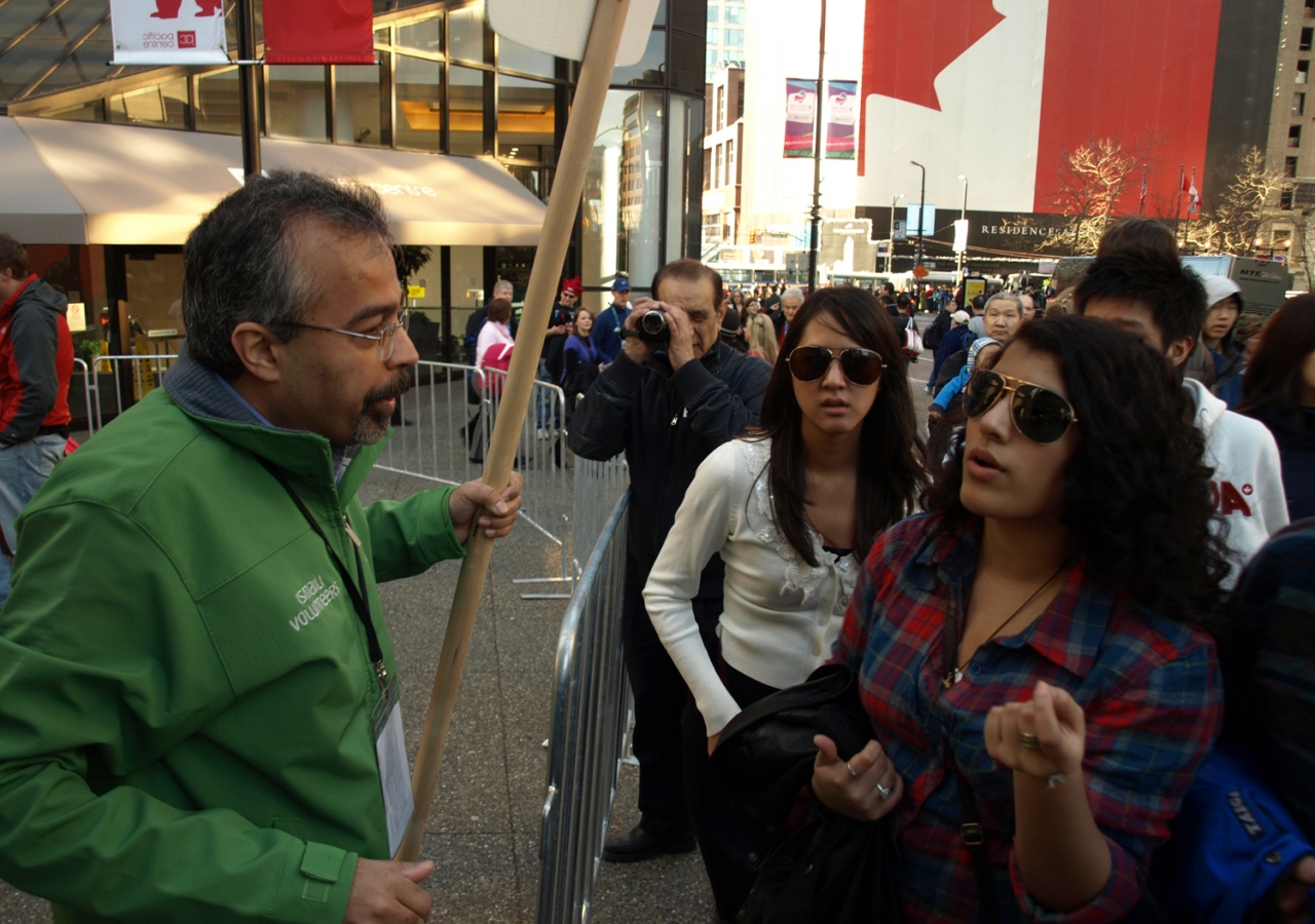 Tourists visiting Vancouver for the 2010 Winter Olympic Games seek assistance from an Ismaili volunteer.