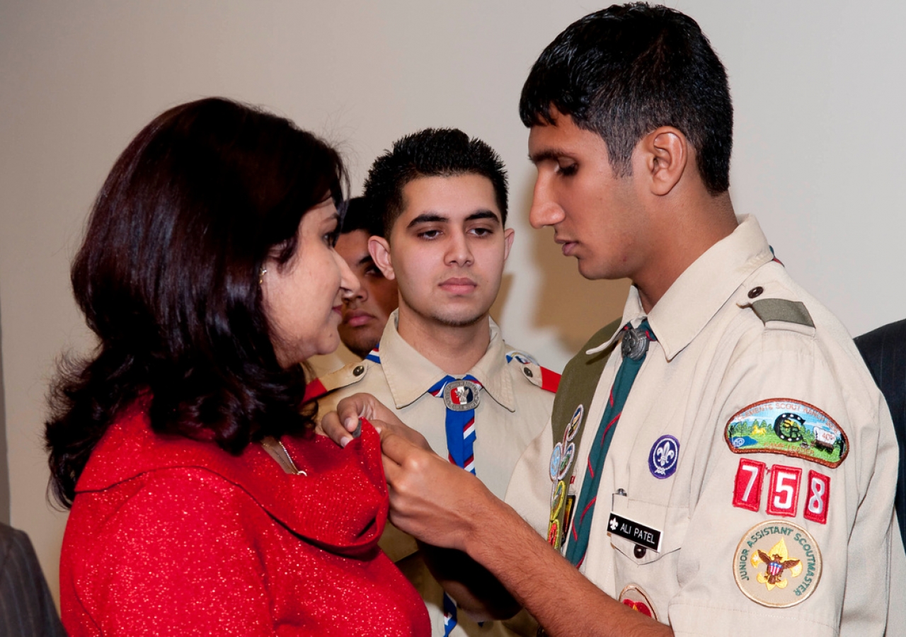 Ali Patel presents his mother with a pin for supporting him throughout his Eagle Scout project. Each of the recipients gave pins to their mothers in appreciation of their support.