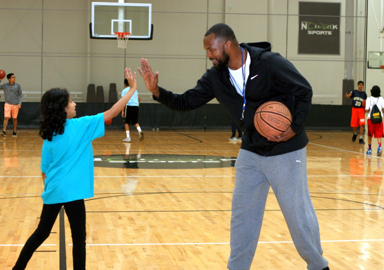 A professional coach giving the youth encouragement for a job well done.