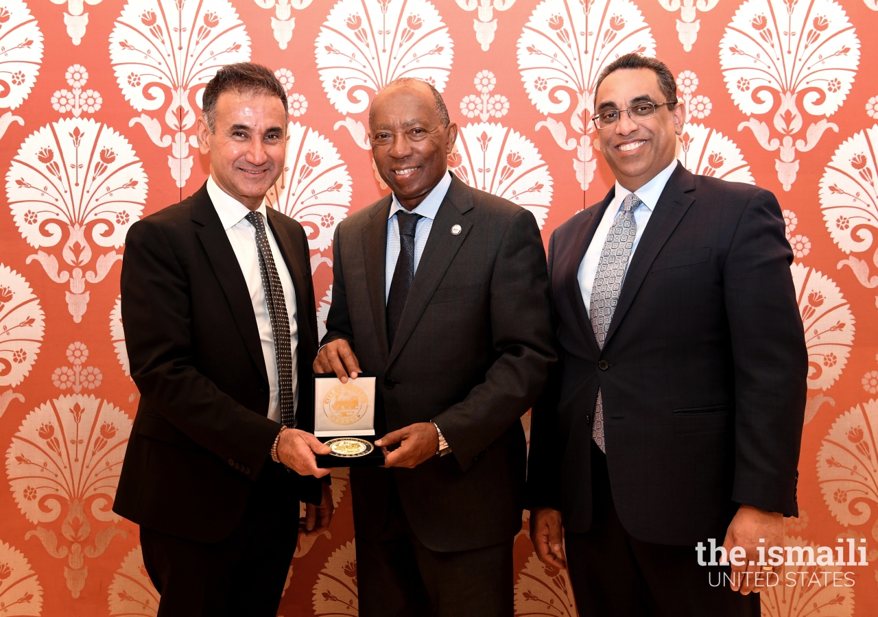 Mayor Sylvester Turner presenting a gift to the President of the Ismaili Council for Canada, Ameerally Kassim-Lakha, joined by the President of the Ismaili Council for USA, Al-Karim Alidina.