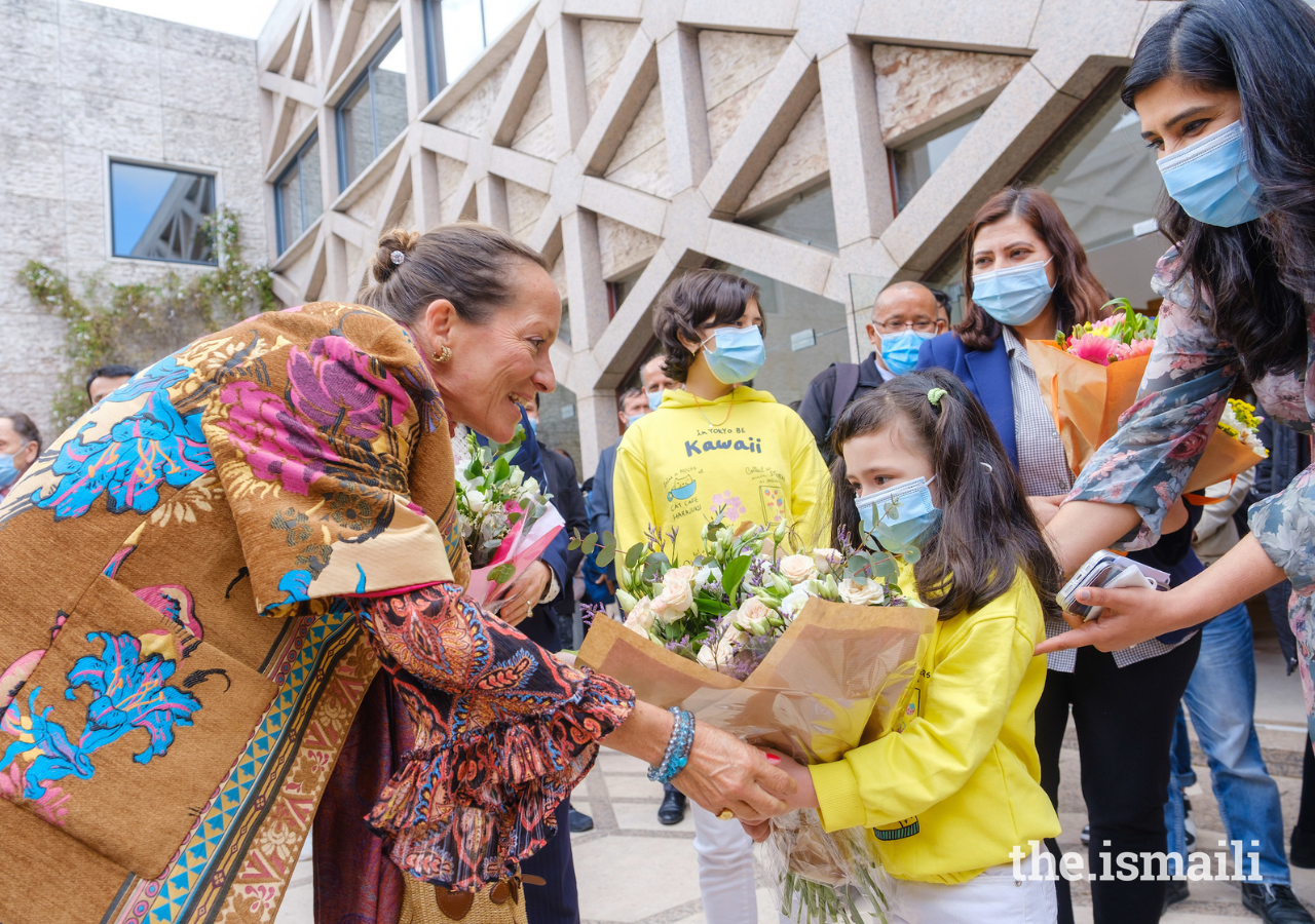 Princess Zahra is presented with a bouquet of flowers by a young girl at the Ismaili Centre, Lisbon, on 30 March 2022.