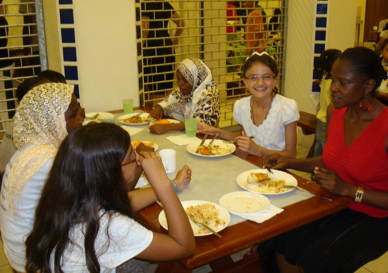 Tajik student Ganjina enjoys a family dinner with her dorm parent and roommates at the Aga Khan Academy in Mombasa.