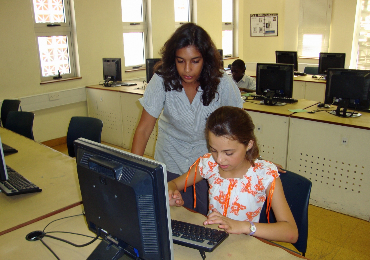 Muslima gets help with a story she is working on for the newspaper club from club supervisor Anjia, a Diploma Programme student.