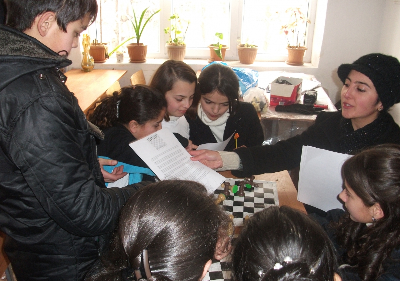 Teaching Fellow Zarniso Mamadsaidova shows the students how to play chess during one of their weekend orientation sessions.