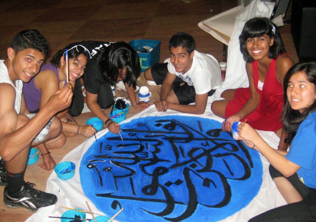 Participants work to create a calligraphy piece for the prayer space.