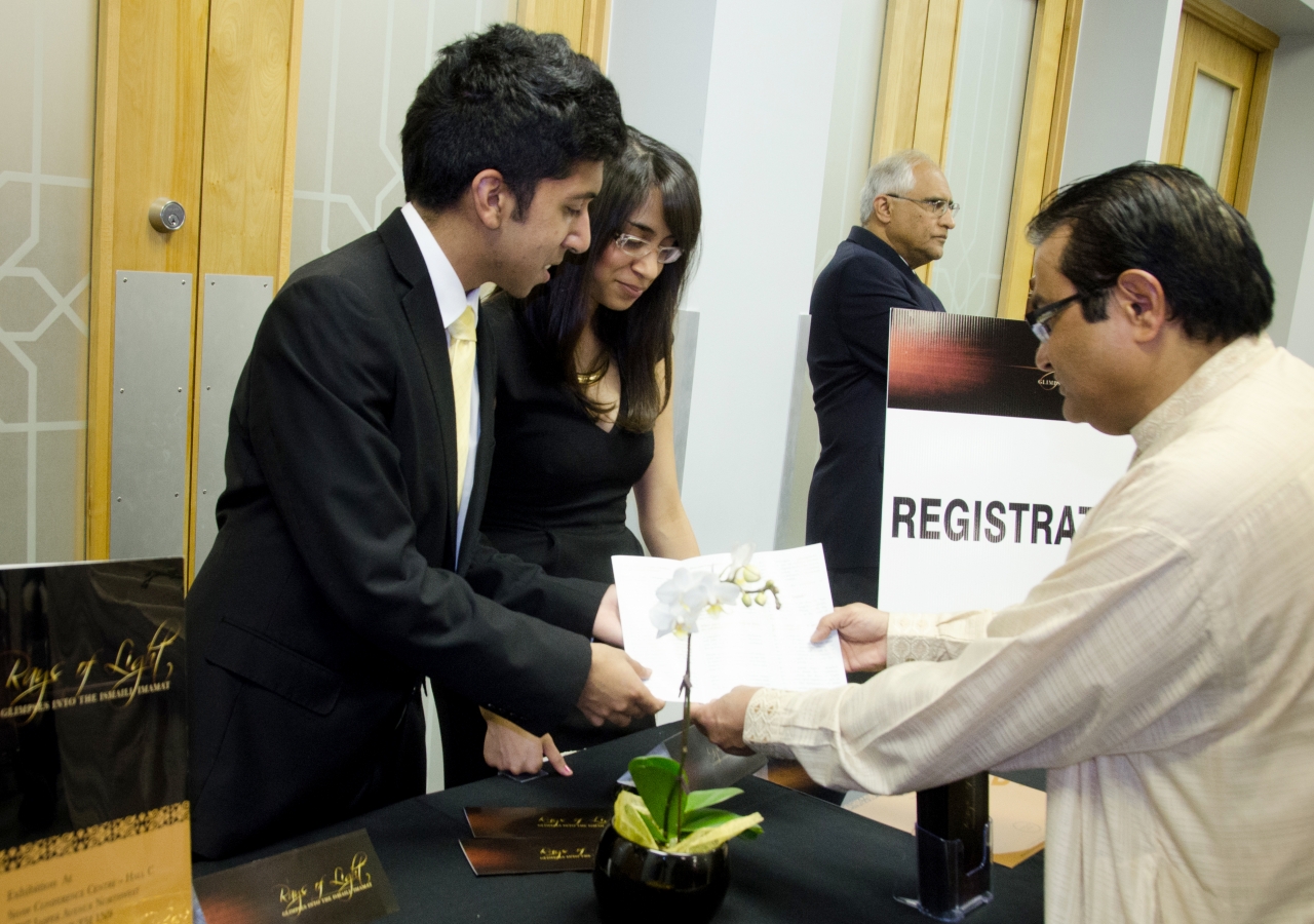 RAYS OF LIGHT ambassadors assist a member of the Edmonton Jamat to register in advance of the exhibition’s Canadian premiere.