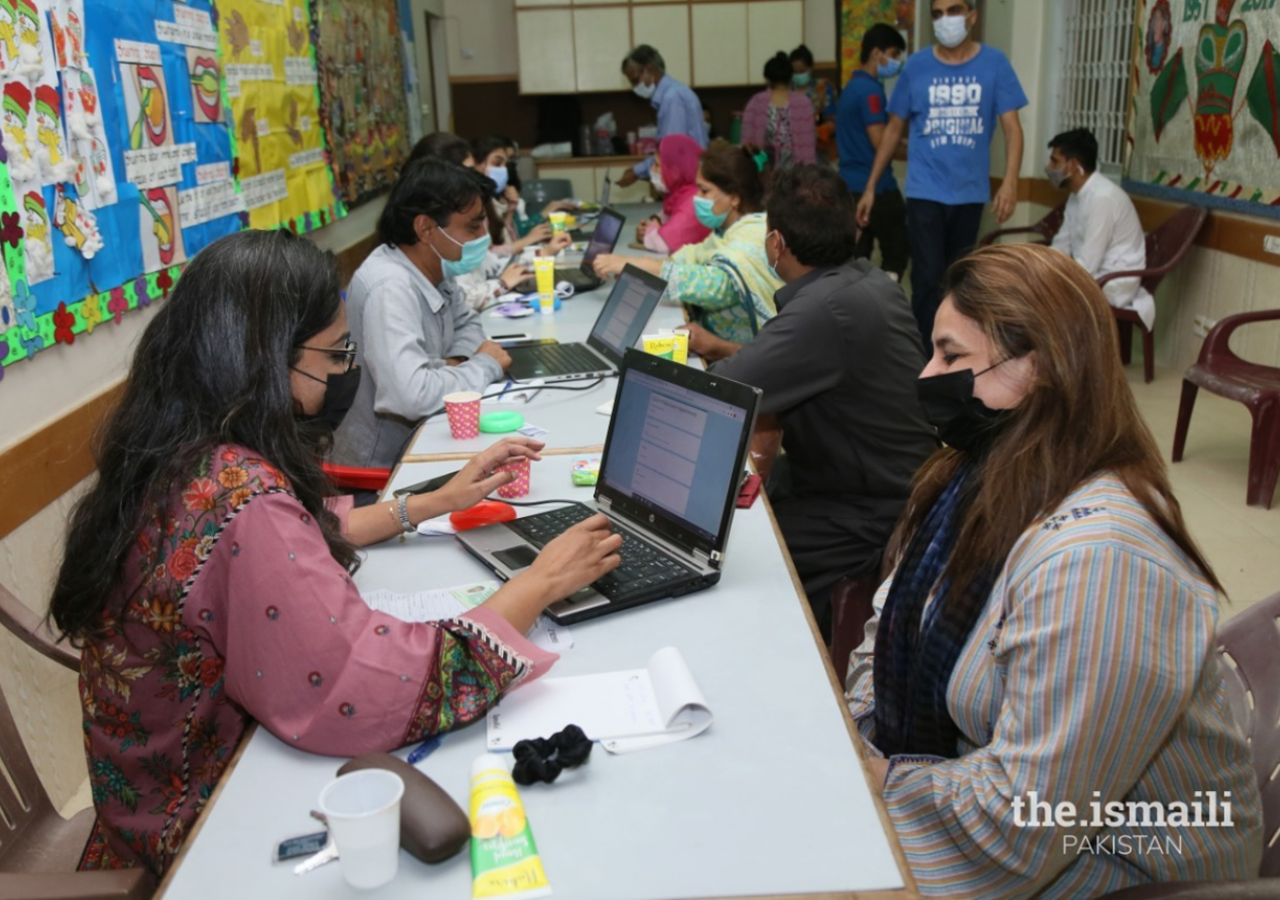 Volunteers collect data from members of the Jamat at the vaccination centre.