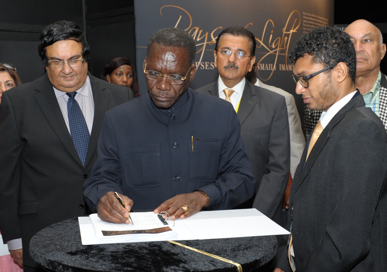 The Right Honourable Mizengo Peter Pinda, Prime Minister of Tanzania, signs the official guest book at the RAYS OF LIGHT exhibition at the Diamond Jubilee Hall in Dar es Salaam.