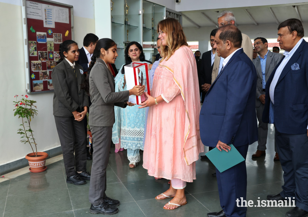 Students from the Aga Khan School in Chitravad offer a flowering plant to Sara.