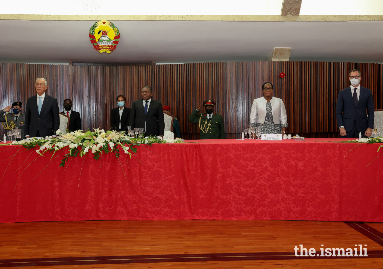 At an official state banquet, Mozambique's President Filipe Nyusi and his wife rise for the Mozambique national anthem, flanked by Prince Rahim and President Marcelo Rebelo de Sousa of Portugal.