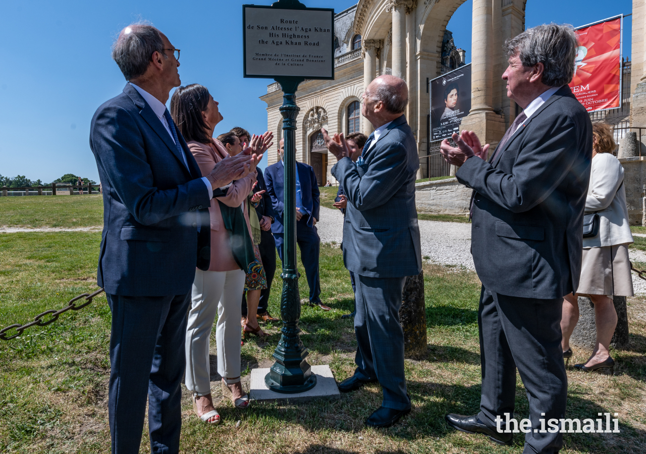 Des invités applaudissent lors de l'inauguration d'un panneau indiquant la "route de Son Altesse l'Aga Khan" à Chantilly.