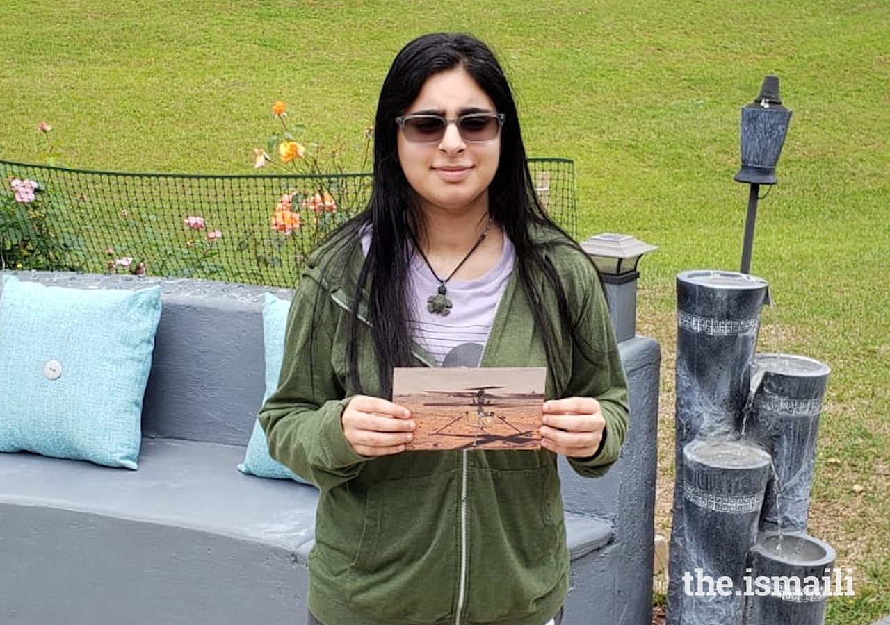 Vaneeza Rupani holds a photo of Ingenuity, the NASA Mars helicopter she named.