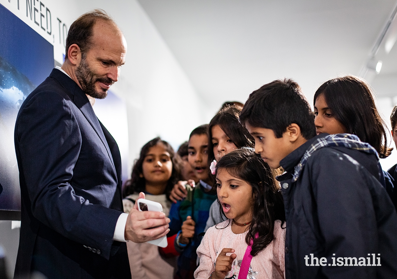 Prince Hussain interacts with young students at The Living Sea photo exhibition in Lisbon.