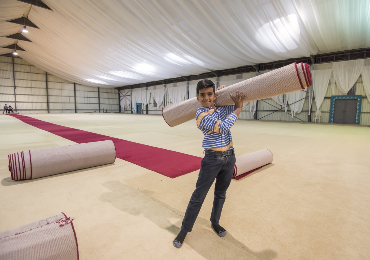 A young volunteer helps to prepare the Darbar hall at Dharkhana Jamatkhana, Nairobi