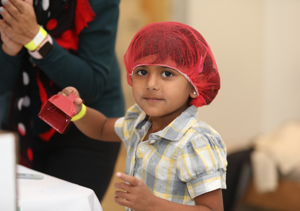 Five-year old Alayna Punjani rings the bell as her group packs a box of meals to help families across Metro Atlanta.