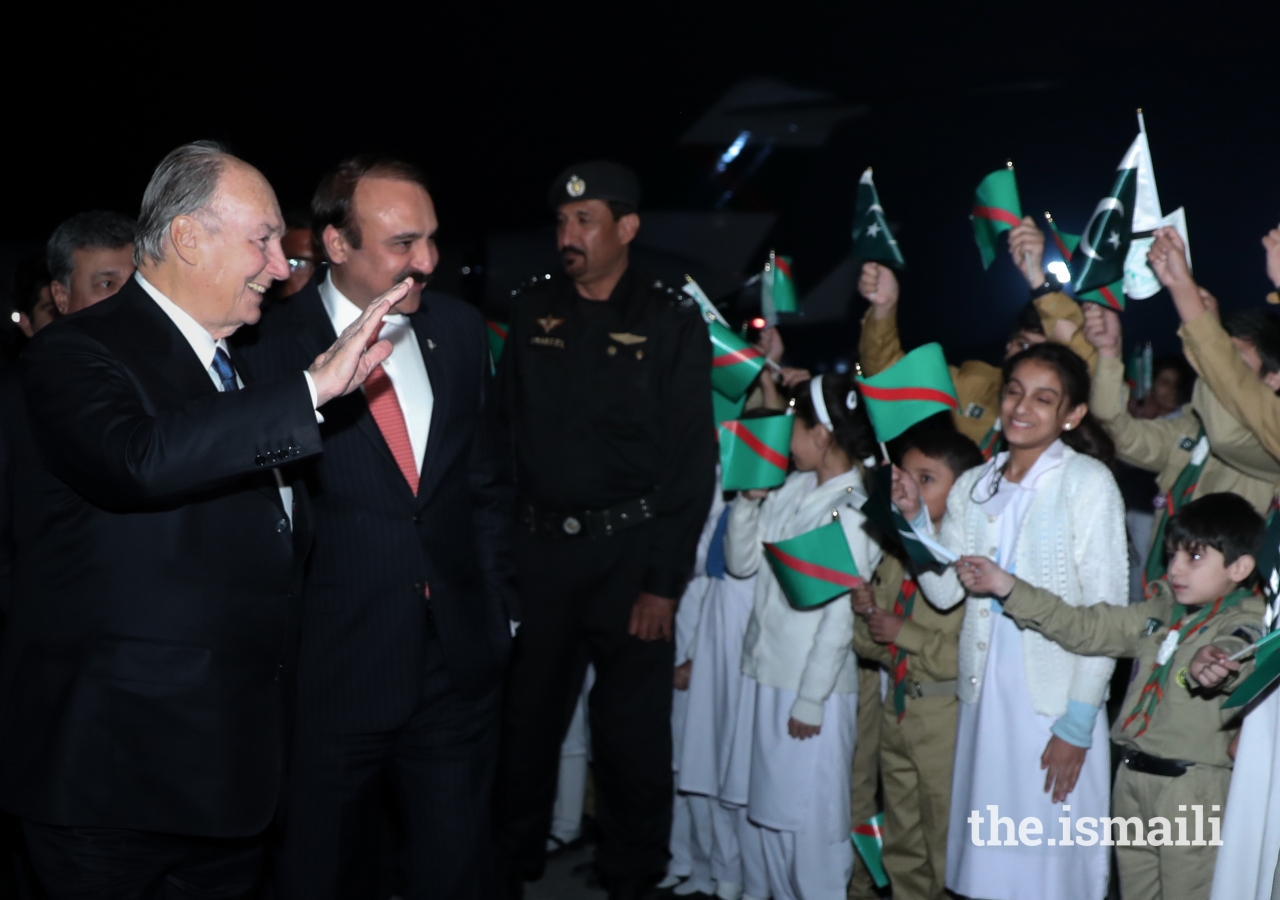 Mawlana Hazar Imam waving happily at the jubilant shaheen scouts and junior guides upon his arrival.