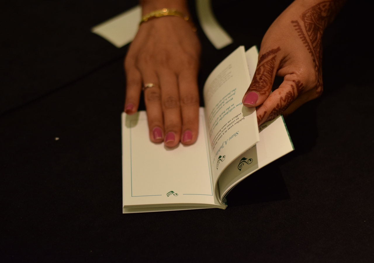 A Jamati member flips through the Jubilee Passport keepsake.