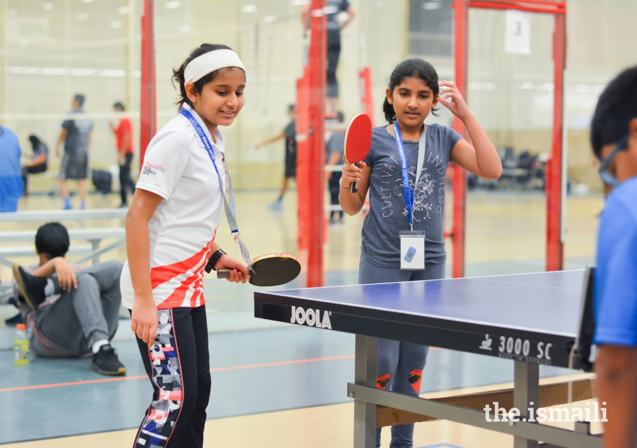 Doubles partners Arzoo Rozani and Zaina Jawaid wait for their opponents to return the ball.