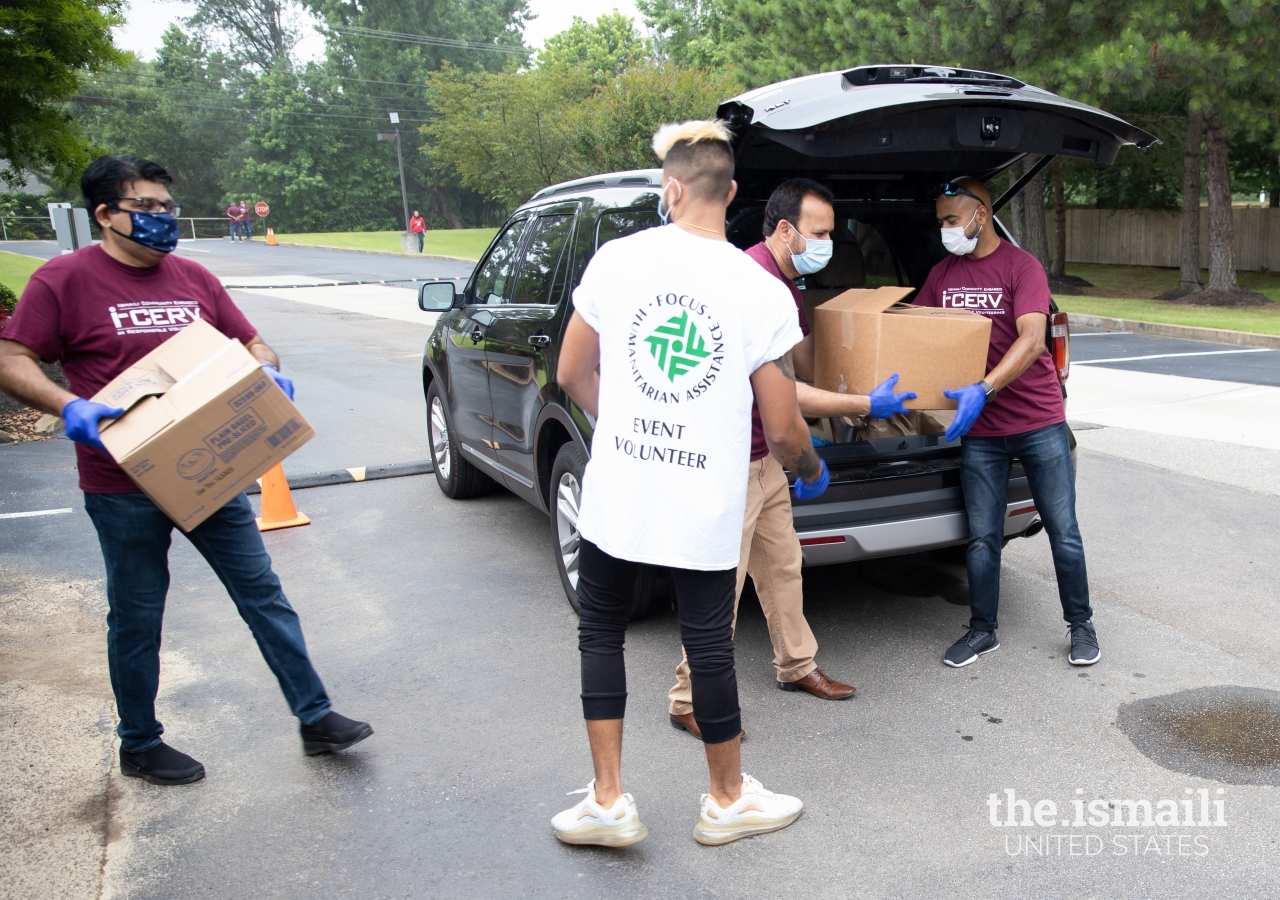 I-CERV and Focus Humanitarian Assistance volunteers loading boxes of food into cars for families in need at the Mobile Food Pantry.