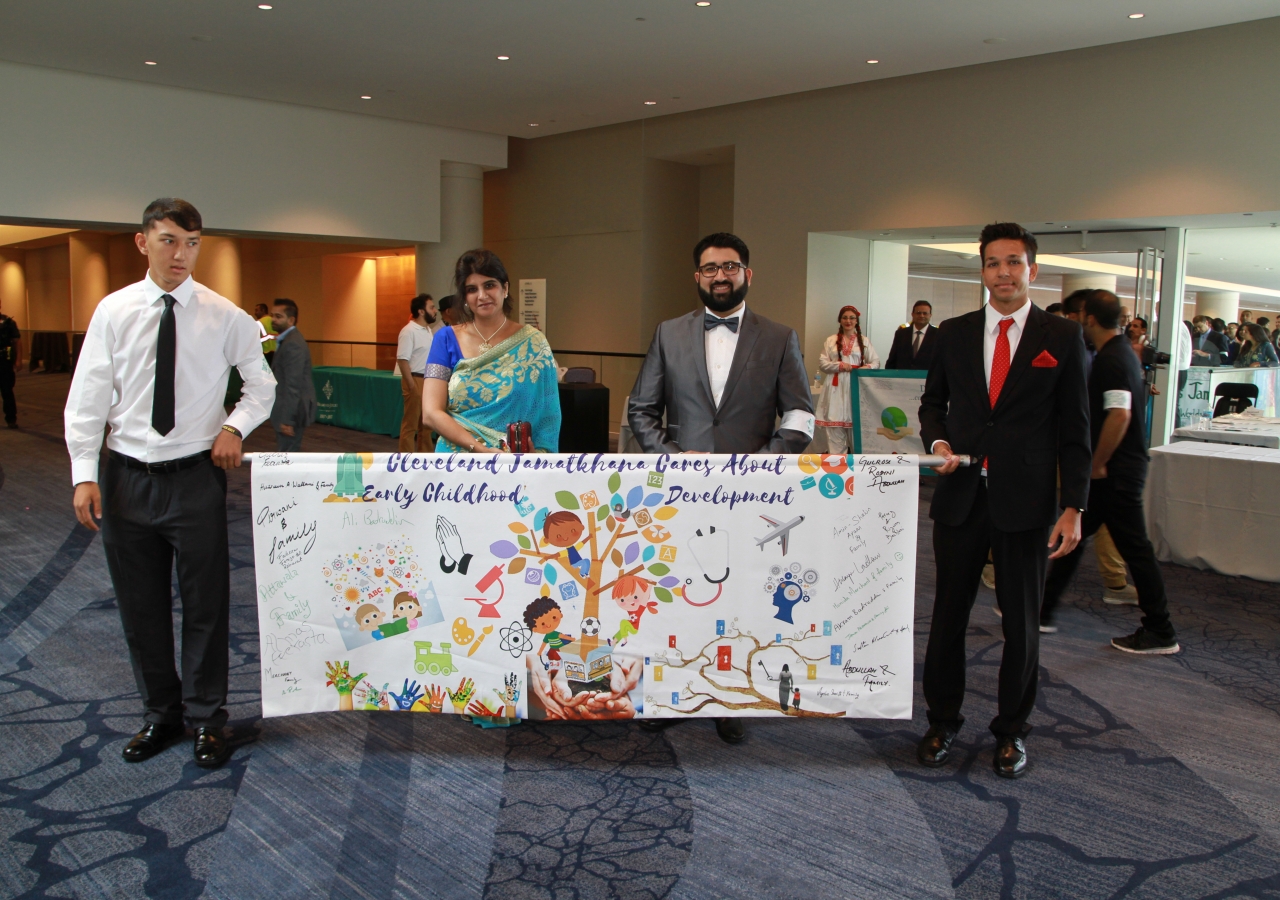 Leadership from the Cleveland Jamat carry their Jubilee Wishes banner, highlighting one of the important Diamond Jubilee goals.