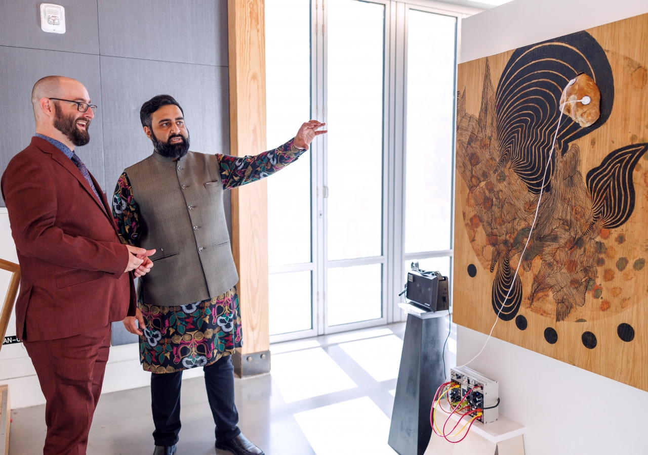 Event co-host Munir Meghjani and a guest viewing the art gallery