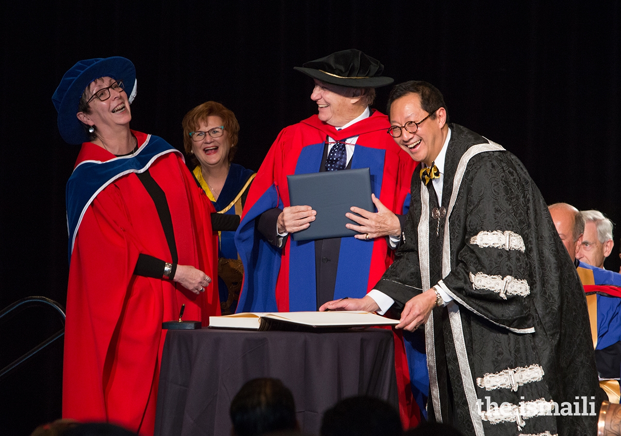 Mawlana Hazar Imam shares a light moment with UBC leadership upon the signing of the register.