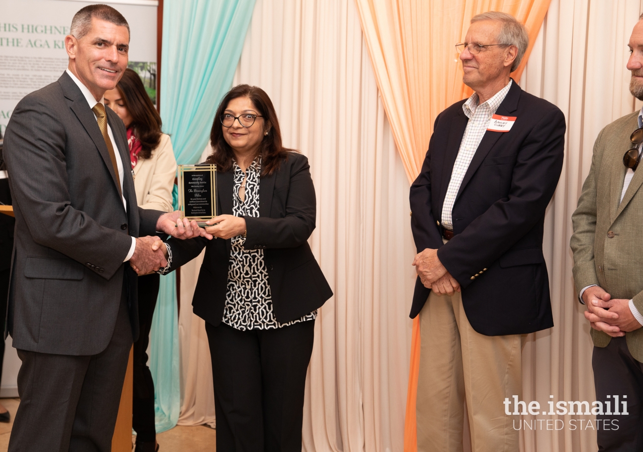 President Salima Jaffer presents an award to first responders in Birmingham Jamatkhana in appreciation of their services.