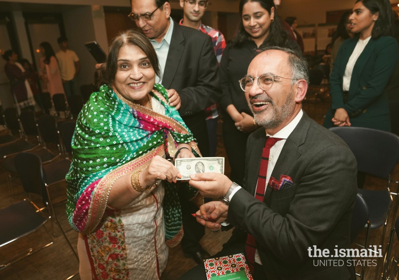 Farrokh Derakshani autographing a $2 bill.