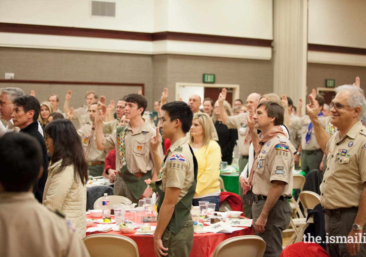 Boy Scouts and Troop leaders raise three three fingers to show "Scout's Honor".