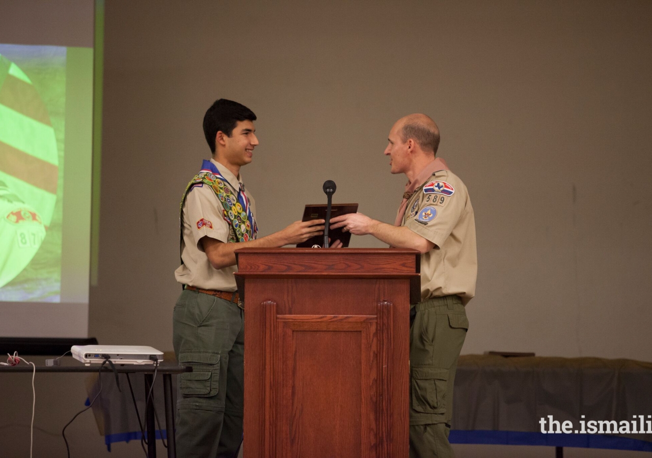 District Chairman Jeff Knowlton presents Aniq an award in recognition of earning 139 merit badges.