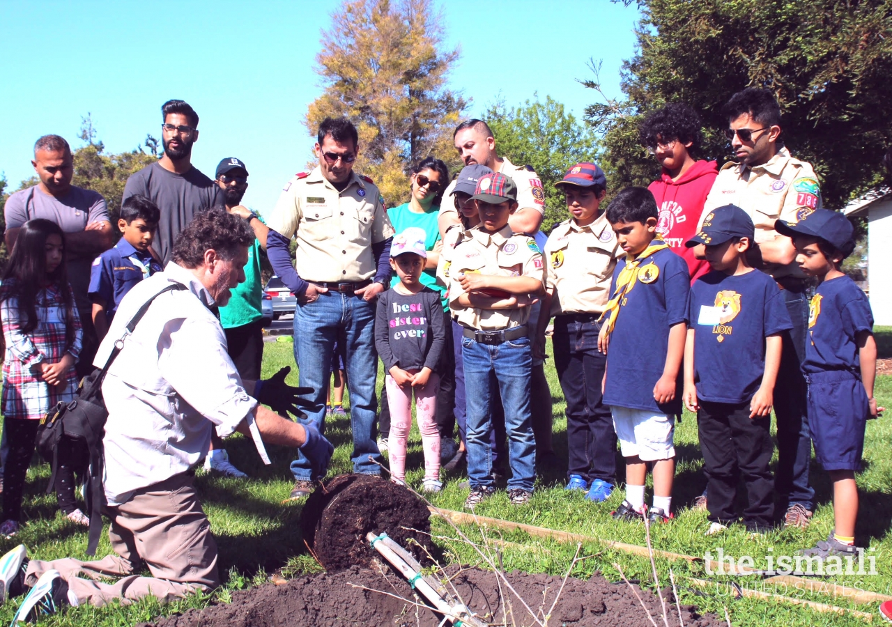 Arborist Lawrence Abbott explains the importance of taking care of our environment to the young Girl and Boy Scouts.