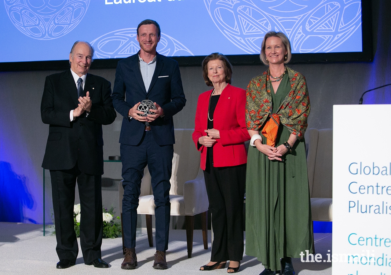 Igor Radulović, on behalf of the group Learning History that is not yet History, poses for a photo with Mawlana Hazar Imam, Global Centre for Pluralism Board Member Huguette Labelle, and Global Centre for Pluralism Secretary General Meredith Preston McGhie.