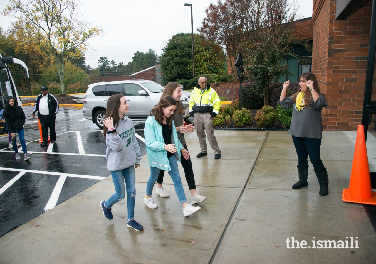 Communications Coordinator, Farida Nurani, welcomes 100 seventh-grade students from The Westminster Schools, as they arrive at the Ismaili Jamatkhana in Norcross.