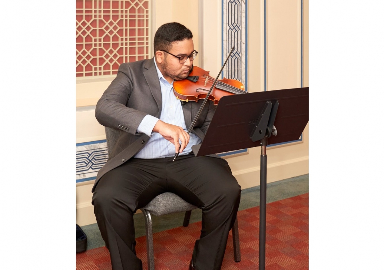 Shazan Samani uses his violin to provide classical background music in Atlanta Headquarters Jamatkhana. 