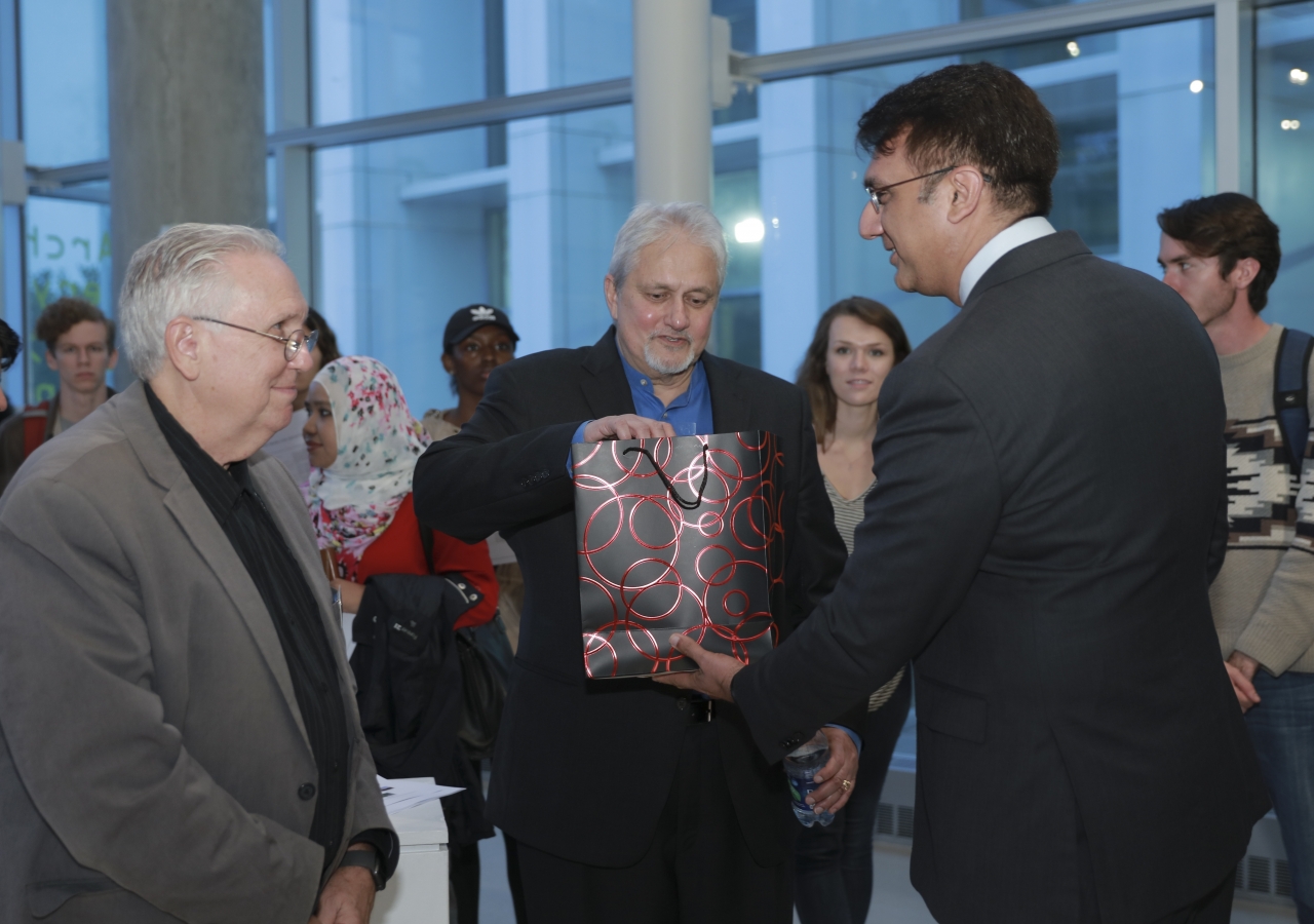 President Murad Abdullah of the Ismaili Council for the Southeast presenting Prof. Khan with a gift, as Prof. Cole looks on.