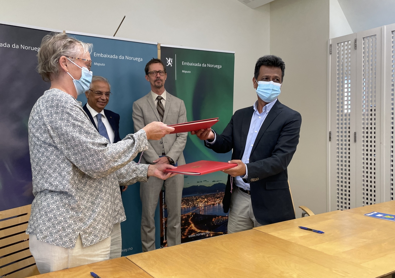 Minister Counsellor of the Norwegian Embassy Sissel Idland (left) and AKF Mozambique National Director Agostinho Mamade (right) exchanging folders after signing the grant agreement with the AKDN Diplomatic Representative Nazim Ahmad (left) and the Norwegian Ambassador Haakon Gram-Johannessen (right) looking on.