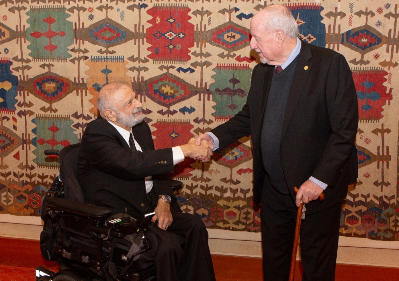 Noorallah Jamal shakes hands with Michael Molloy, the immigration officer who facilitated his entry into Canada