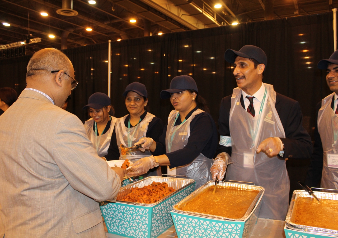 Volunteer Munawwer Bhojani and others from Sugar Land Jamatkhana help serve the Jamat a traditional dinner. 